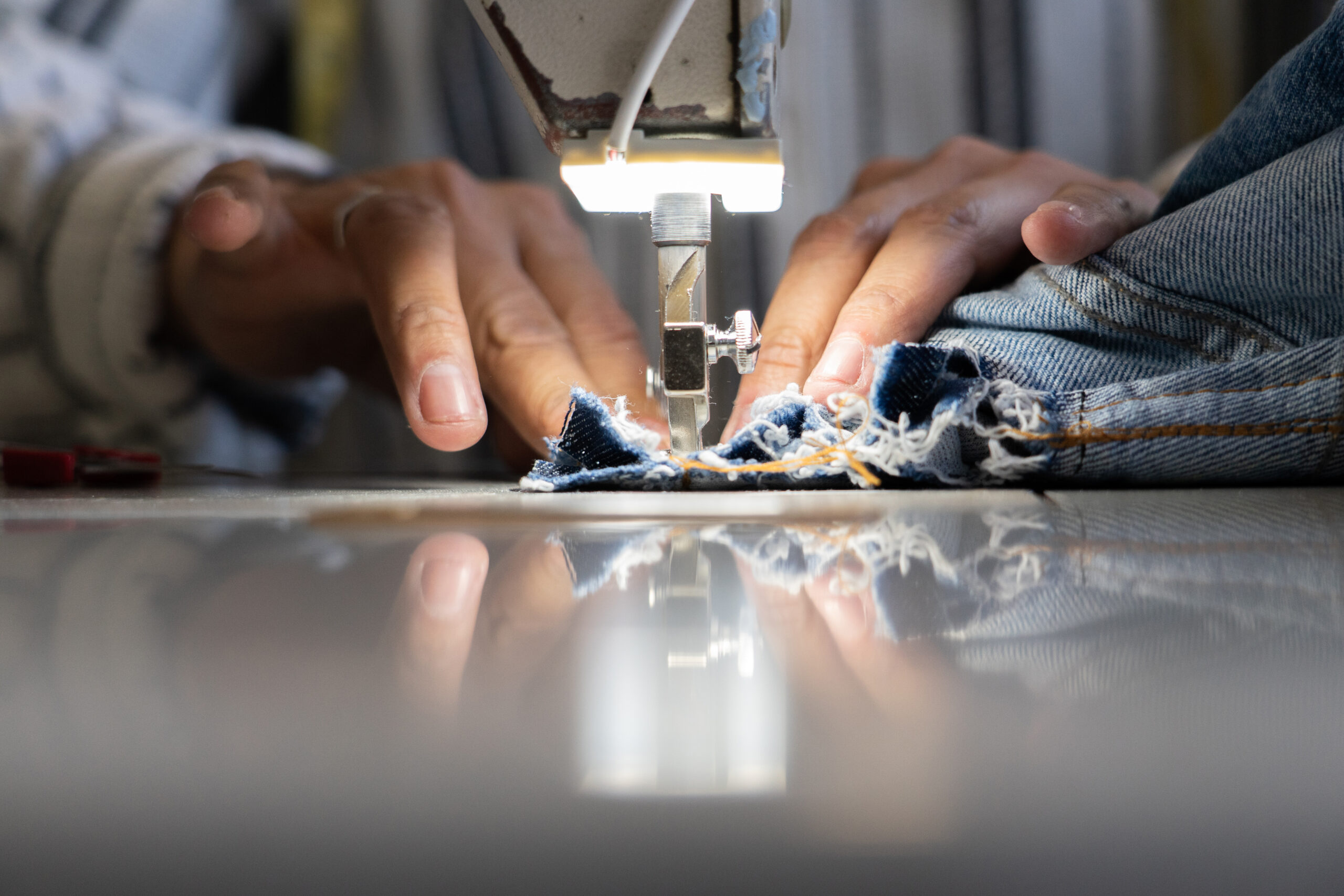 Man's hands sewing on a sewing machine
