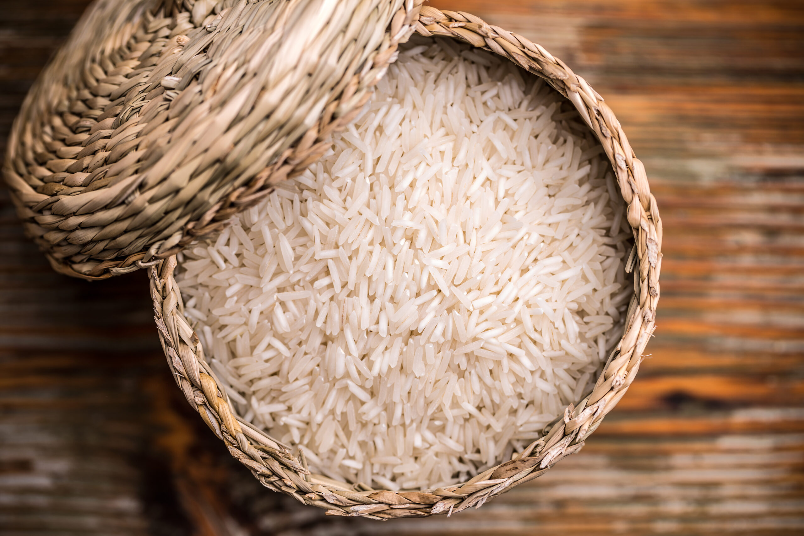 Top view of long grain rice in a wicker basket